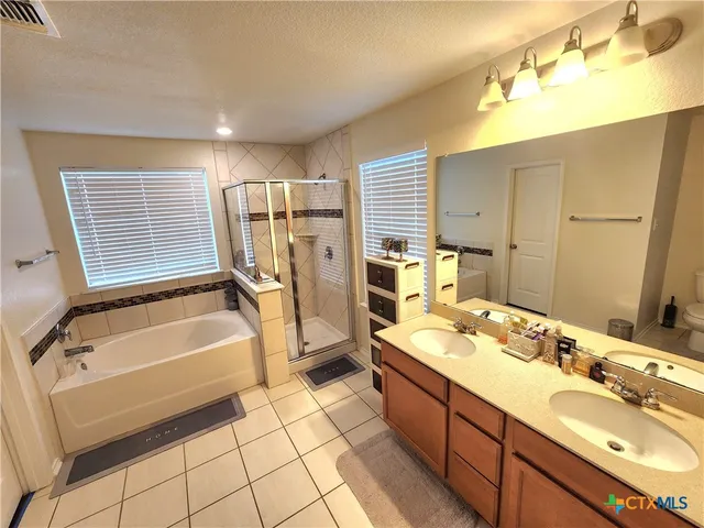 a spacious bathroom with a tub sink and mirror