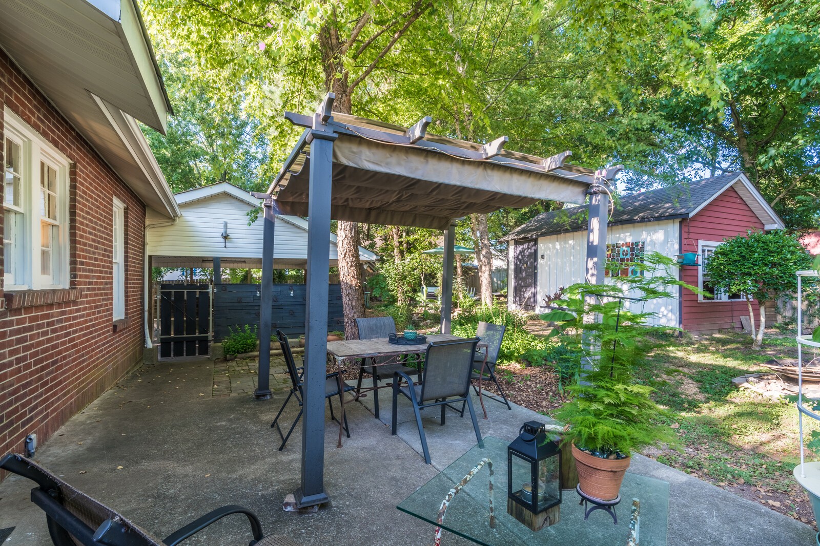 410 Connell Street Springfield, TN 37172 - Photo 7 of 24 a view of a patio with table and chairs potted plants and floor to ceiling window and wooden fence