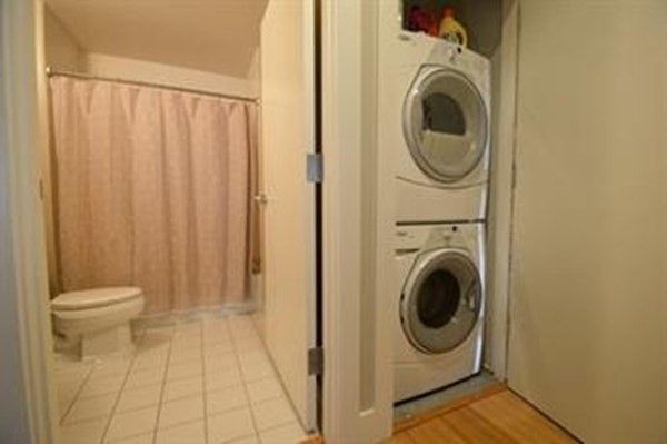 a view of a bathroom with washing machine and a view of bedroom