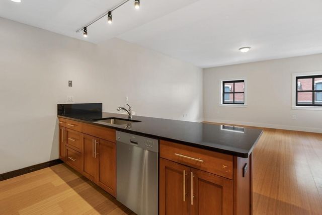 a kitchen with granite countertop sink and cabinets