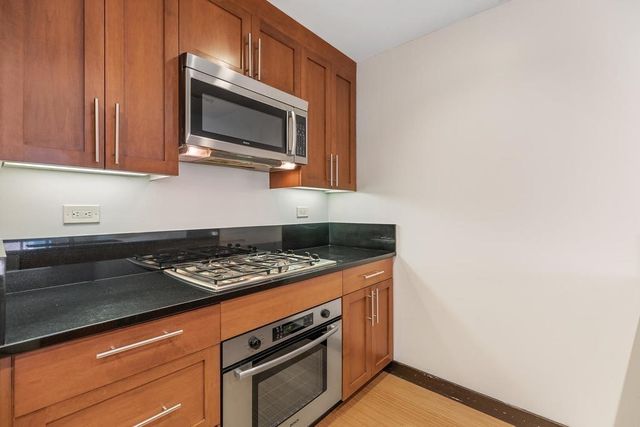 a kitchen with stainless steel appliances a stove microwave and sink