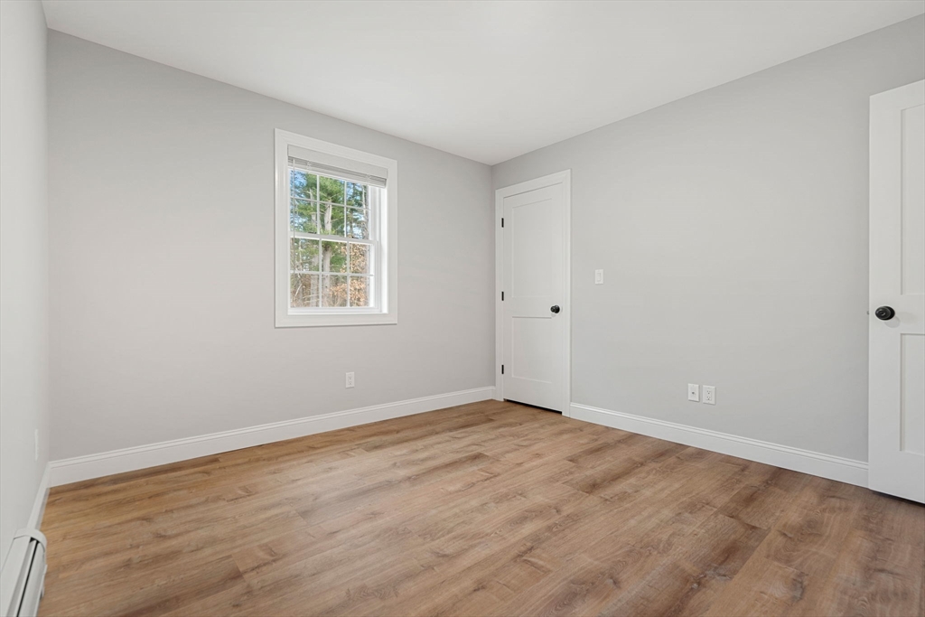 249 Brookside Road Orange, MA 01364 - Photo 23 of 37 a view of an empty room with wooden floor and a window