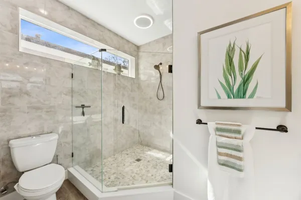 a bedroom with a bed and a flat tv screen on dresser