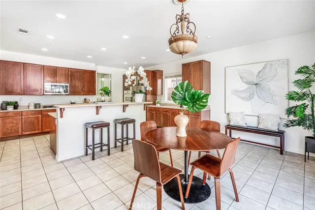 a kitchen with stainless steel appliances a table and chairs in it