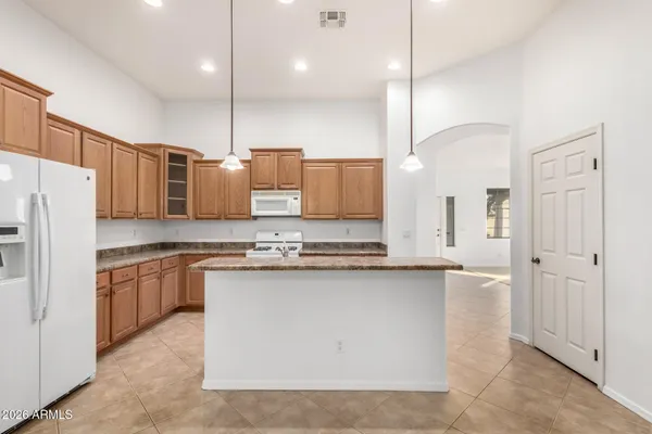a view of an empty room with kitchen appliances and a window