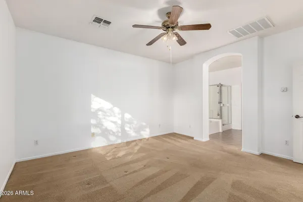 a view of a big room with windows and chandelier fan