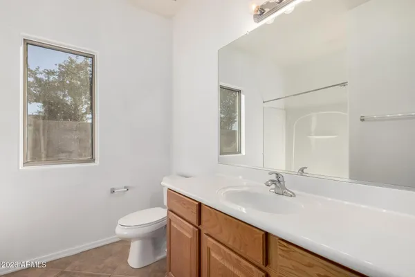a bathroom with a sink vanity granite toilet and a mirror