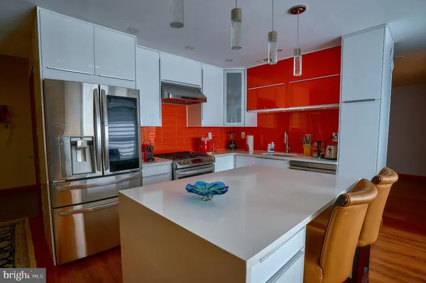 a kitchen with stainless steel appliances kitchen island granite countertop a table and chairs