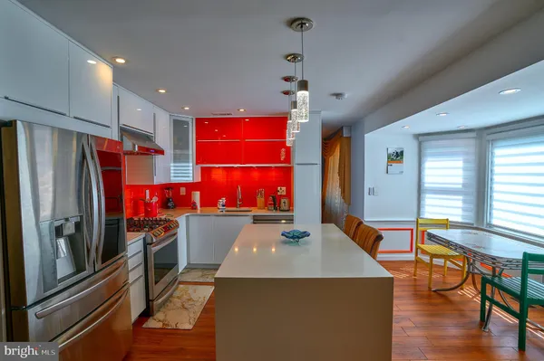 a kitchen with stainless steel appliances granite countertop a sink a stove and a refrigerator