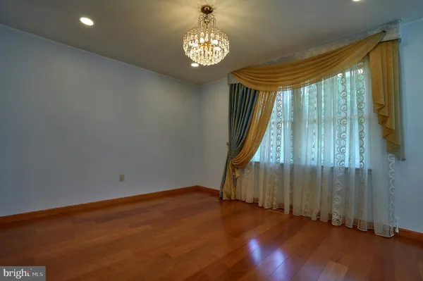 an empty room with wooden floor and mirror
