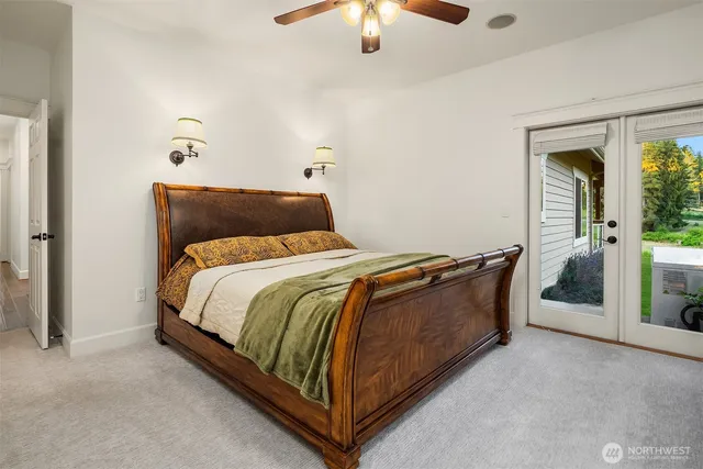 a bed sitting in a bedroom next to a window and a chandelier