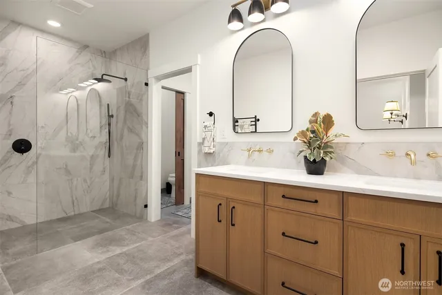 a bathroom with a double vanity sink mirror and shower