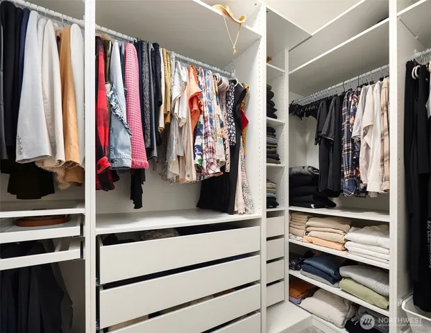 a view of walk in closet with clothes and shoes