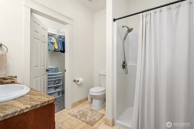 a bathroom with a granite countertop sink toilet and shower