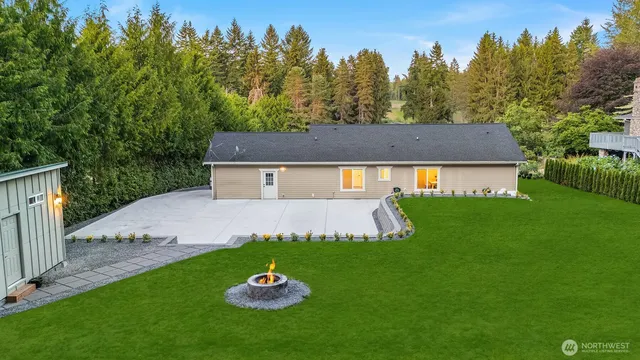 a view of a white house with a yard and tree in it