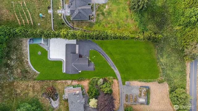 an aerial view of a house with a garden and lake view