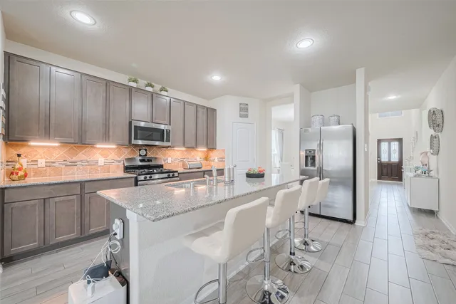 a large kitchen with stainless steel appliances lots of white cabinets