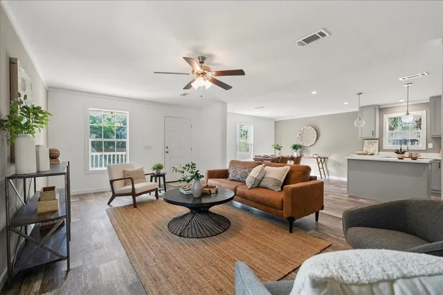 a living room with furniture kitchen view and a window