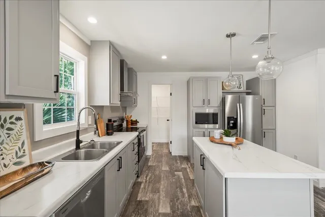 a kitchen with stainless steel appliances kitchen island a sink stove and refrigerator