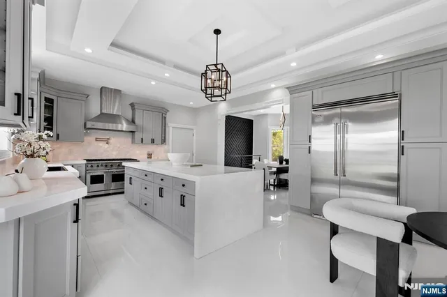 a kitchen with stainless steel appliances kitchen island granite countertop a stove refrigerator and cabinets