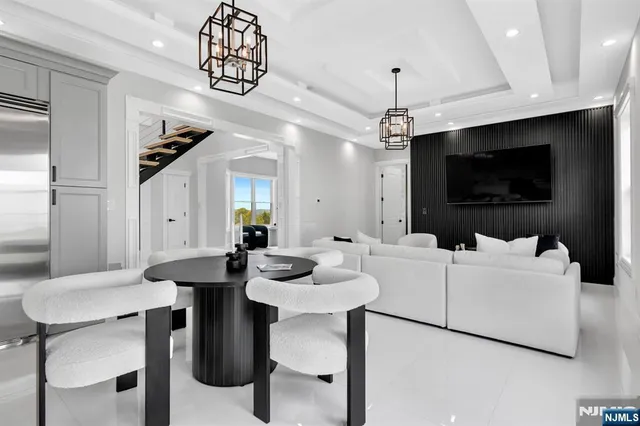 a living room with furniture a flat screen tv and kitchen view