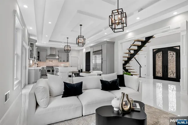 a living room with furniture kitchen view and a chandelier