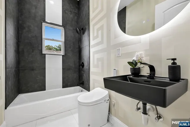 a bathroom with a sink a toilet and mirror