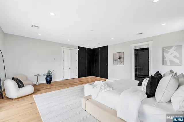 a bedroom with a bed and wooden floor