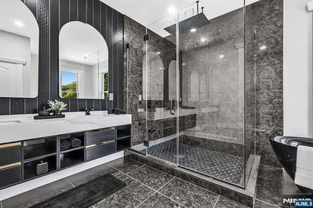 a bathroom with a double vanity sink mirror and shower