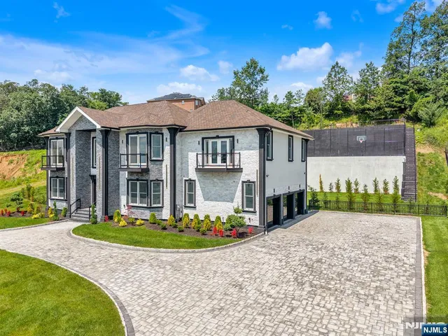 a front view of a house with a yard and potted plants