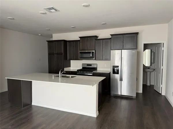 a kitchen with stainless steel appliances a refrigerator and a stove top oven