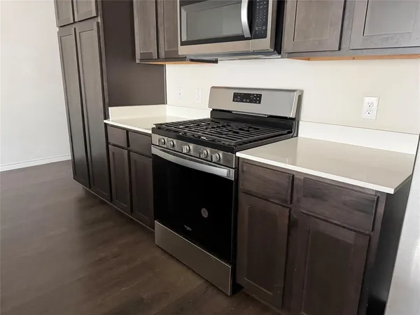 a kitchen with granite countertop cabinets and steel stove top oven