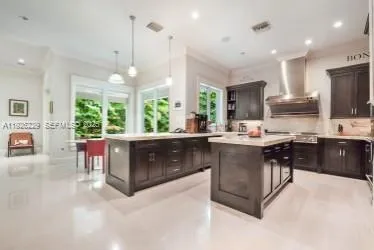 a kitchen with kitchen island a stove a table and chairs in it