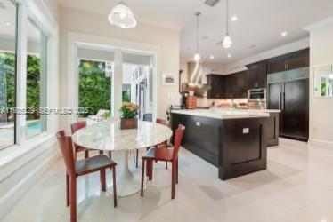 7821 Southwest 54th Court Miami, FL 33143 - Photo 7 of 22 a kitchen with kitchen island a stove a table and chairs in it