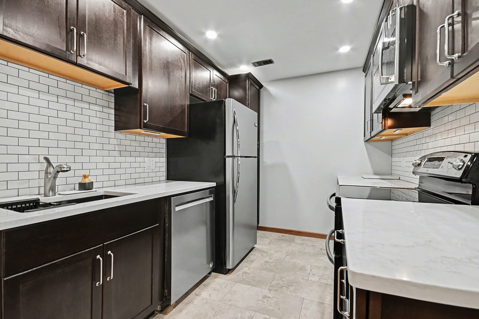 1484 Stonebridge Circle, Unit B6 Wheaton, IL 60189 - Photo 3 of 16 a kitchen with stainless steel appliances a sink stove and refrigerator