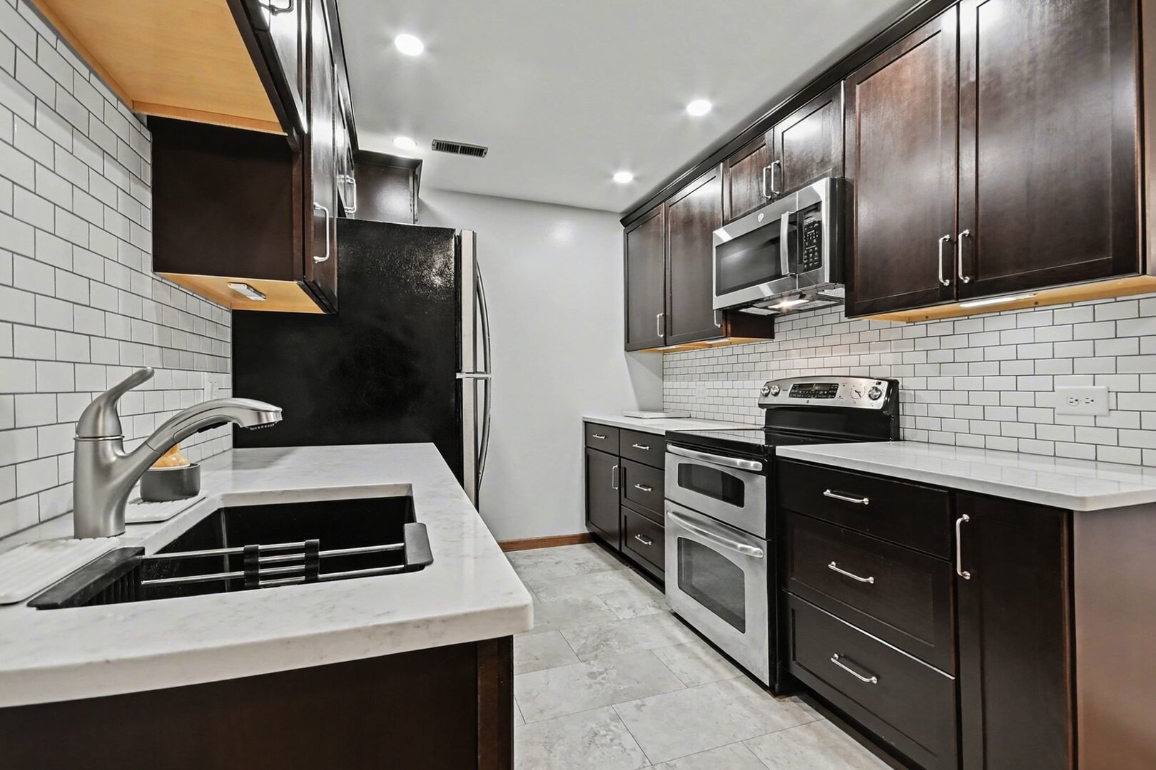 1484 Stonebridge Circle, Unit B6 Wheaton, IL 60189 - Photo 4 of 16 a kitchen with stainless steel appliances granite countertop a sink stove and refrigerator