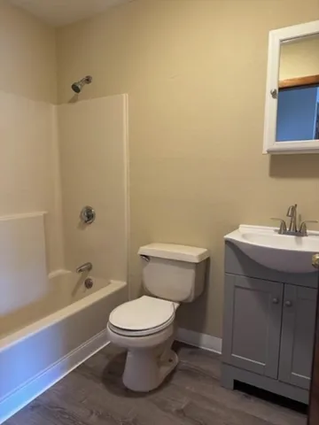 a white toilet sitting next to a bath tub