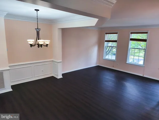 an empty room with wooden floor windows and ceiling fan
