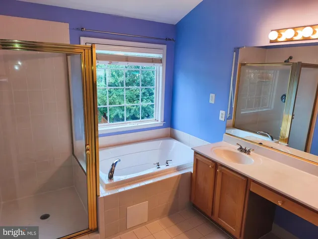 a bathroom with a tub sink and mirror
