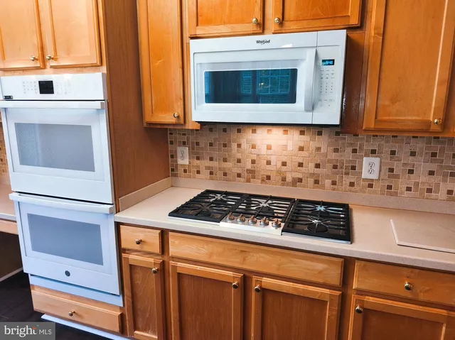 a kitchen with stainless steel appliances granite countertop cabinets and a stove top oven