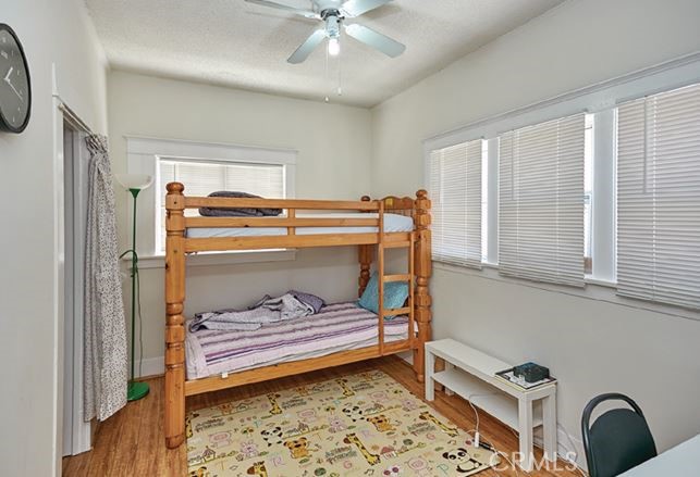 412 East 16th Street Long Beach, CA 90813 - Photo 5 of 8 a bedroom with a bed and a large window with wooden floor