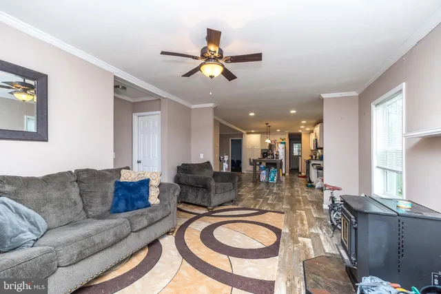 a living room with couches a fireplace and a chandelier