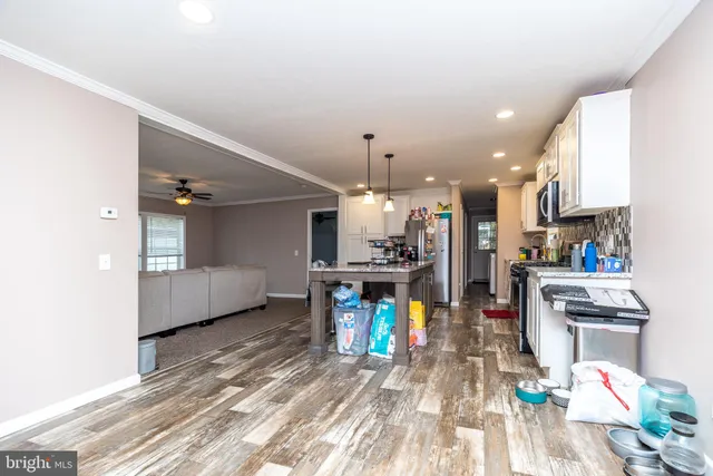 a kitchen view with stainless steel appliances refrigerator stove dining table and chairs