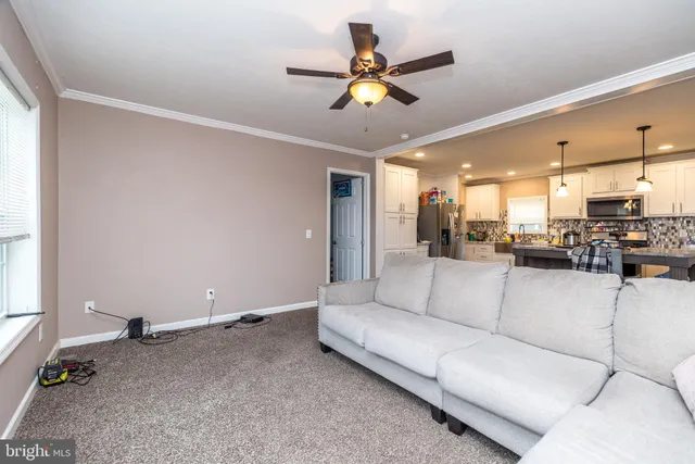 a living room with furniture and kitchen view