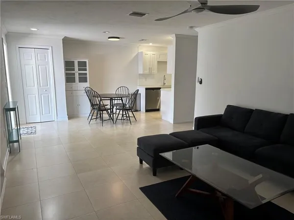 a living room with furniture and a dining table with rug