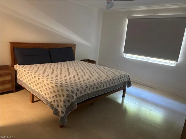 a bed sitting in a bedroom next to a window