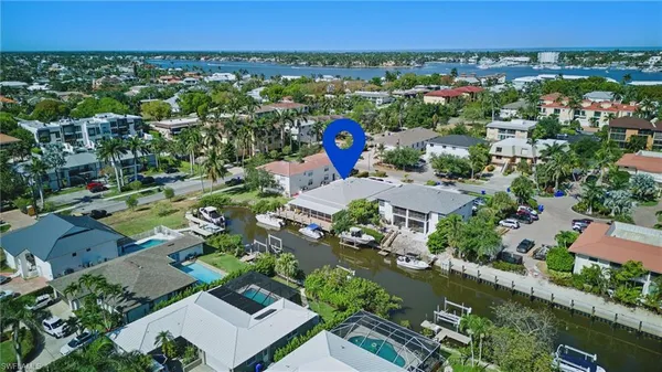 an aerial view of a city with lots of residential buildings ocean and mountain view in back
