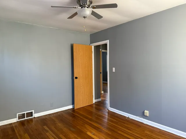 a view of an empty room with wooden floor