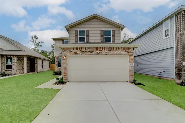a front view of house with yard and garage