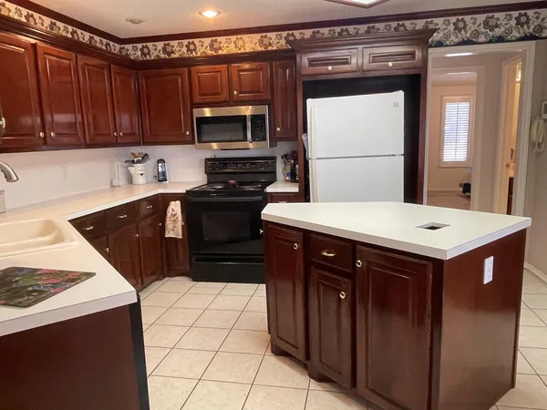 a kitchen with a sink a stove top oven and cabinets